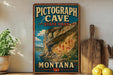 A vintage-style sign for Pictograph Cave, a State Park in Montana, featuring an illustration of the cave and its surroundings.
