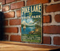 A vintage-style metal sign for Pike Lake State Park in Ohio, featuring a scenic illustration of the lake and surrounding landscape.