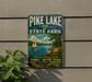 A vintage-style metal sign for Pike Lake State Park, featuring a sailboat on a lake and a scenic landscape.
