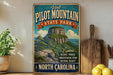 a vintage-style sign for Pilot Mountain State Park in North Carolina, with a mountain landscape and text promoting the park's scenic trails, breathtaking views, and natural beauty.