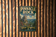 A vintage metal sign for Pinnacle Rock State Park in West Virginia, featuring a scenic mountain landscape.