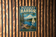 A vintage metal sign for Pleasant Harbor State Park in Washington, featuring a scenic landscape with a sailboat on the water.