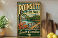 A vintage-style sign for Poinsett State Park in South Carolina, featuring a scenic image of a wooden bridge over a lake surrounded by pine trees and pink flowers.