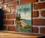 A vintage-style metal sign for Point Beach State Forest in Wisconsin, featuring a scenic image of a beach and forest landscape.