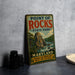 A vintage metal sign for Point of Rocks State Park in Maryland, featuring a scenic illustration of a mountain and river.