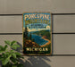 A vintage-style metal sign for Porcupine Mountains Wilderness State Park in Michigan, featuring a scenic landscape with a lake, mountains, and pine trees.