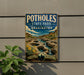 A vintage-style sign for Potholes State Park in Washington, featuring a scenic landscape with a river, mountains, and a waterfall.