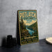 A vintage-style metal sign for Potlatch State Park, featuring a scenic landscape with pine trees and a river, is displayed on a gray concrete surface.