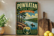 a vintage-style poster of Powhatan State Park, Virginia, with a scenic illustration of a person canoeing on a river surrounded by trees. The poster is displayed on a wall, with a wooden cutting board and some lemons visible in the foreground.