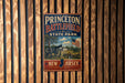 A vintage metal sign for Princeton Battlefield State Park in New Jersey, featuring an illustration of a cannon and a flag.