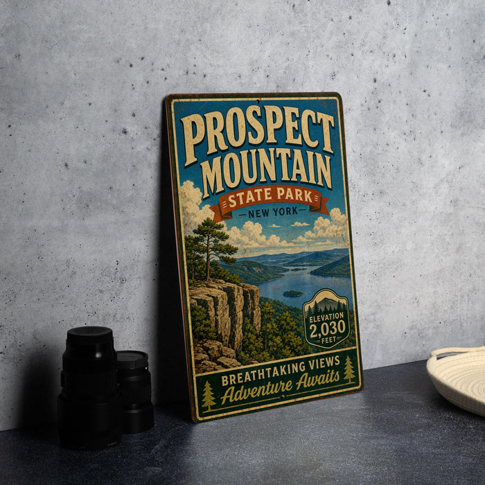 A vintage-style metal sign for Prospect Mountain State Park in New York, featuring a scenic landscape with a lake and mountains.