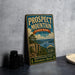 A vintage-style metal sign for Prospect Mountain State Park in New York, featuring a scenic landscape with a lake and mountains.
