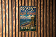 A vintage metal sign for Prospect State Scenic Viewpoint in Oregon, featuring a mountain landscape and a stone monument.