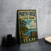 A vintage-style metal sign for Purity Creek State Park in Texas, featuring a scenic illustration of a lake, trees, and a sailboat.