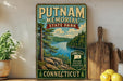 A vintage-style sign for Putnam Memorial State Park in Connecticut, featuring a scenic landscape with a lake and pine trees.
