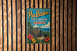 A vintage-style metal sign for Pu'uh Ualakaa State Wayside in Hawaii, featuring a tropical landscape with palm trees, flowers, and a mountain in the background.