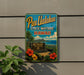 A vintage-style sign for Pu'uh Ualakaa State Wayside in Hawaii, featuring a tropical landscape with palm trees, flowers, and a beach.