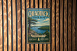 A vintage-style sign for Quad Dick State Park, featuring a scenic landscape with a lake and mountains in the background.