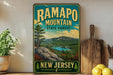 A vintage-style sign for Ramapo Mountain State Forest in New Jersey, featuring a scenic landscape with mountains, trees, and a river.