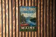 A vintage metal sign for Range Ponds State Park in Maine, featuring a scenic image of a lake with a red canoe and pine trees.