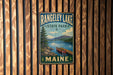 A vintage metal sign for Rangeley Lake State Park in Maine, featuring a scenic illustration of a lake, mountains, and a canoe.