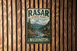 A vintage metal sign for the state park of Washington, featuring a mountain landscape with a waterfall.