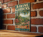 A vintage-style metal sign for Ravine Gardens State Park in Florida, featuring a scenic illustration of a winding path surrounded by lush greenery and colorful flowers.