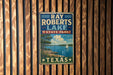 A vintage-style sign for Ray Roberts Lake, a state park in Texas, featuring a scenic illustration of a lake, trees, and a sailboat.