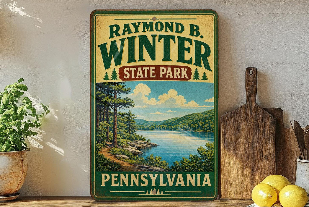 A vintage-style sign for Raymond Winter State Park in Pennsylvania, featuring a scenic landscape with a lake and mountains.