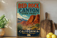 A vintage-style metal sign for Red Rock Canyon State Park in California, featuring a scenic illustration of the canyon landscape.