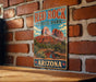 A vintage-style metal sign for Red Rock State Park in Arizona, featuring a scenic illustration of the park's landscape.