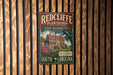 A vintage-style metal sign for Redcliffe Plantation, a historic site in South Carolina, is displayed on a wooden wall.
