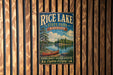 A vintage-style metal sign for Rice Lake State Park in Minnesota, featuring a scenic illustration of a lake, canoe, and forest.