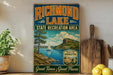 A vintage-style sign for Richmond Lake, the State Recreation Area, with a scenic illustration of a lake, mountains, and a sailboat.