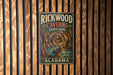 A vintage metal sign for Rickwood Caves State Park in Alabama, featuring an illustration of the cave system.