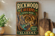 A vintage-style sign for Rickwood Caves State Park in Alabama, featuring an illustration of the cave system and the park's name.