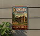 A vintage-style sign for Riordan Mansion State Historic Park in Arizona, featuring a wooden cabin surrounded by trees and mountains.