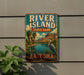 A vintage-style sign for River Island State Park in Arizona, featuring a scenic landscape with palm trees, mountains, and a bird.