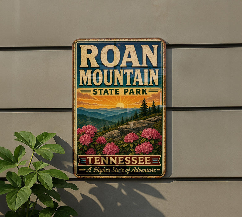A vintage-style metal sign for Roan Mountain State Park in Tennessee, featuring a scenic landscape with mountains, pine trees, and pink flowers.