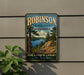 A vintage-style metal sign for Robinson State Park in Massachusetts, featuring a scenic landscape with pine trees, a lake, and mountains.