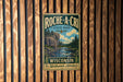 A vintage-style metal sign for Roche-A-CRI State Park in Wisconsin, featuring a scenic landscape with a river and pine trees.