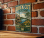 A vintage-style metal sign for Rock Cut State Park in Illinois, featuring a scenic landscape with a lake, mountains, and flowers.