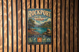 A vintage metal sign for Rockport State Park in Utah, featuring a scenic landscape with mountains, a lake, and a tree.