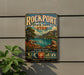 A vintage-style metal sign for Rockport State Park in Utah, featuring a scenic landscape with mountains, water, and a lake.