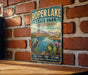 A vintage-style metal sign for Roper Lake State Park in Arizona, featuring a scenic landscape with mountains, a lake, and various flora and fauna.
