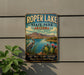 A vintage-style metal sign for Roper Lake State Park in Arizona, featuring a scenic landscape with mountains, a lake, and various plants and wildlife.
