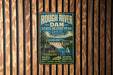A vintage metal sign for Rough River Dam State Resort Park in Kentucky, featuring a scenic image of a waterfall and a cabin.