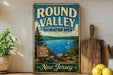 a vintage-style sign for the Round Valley Recreation Area in New Jersey, with a scenic lake and mountains in the background.