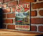 A vintage-style metal sign for Route 66 State Park in Missouri, featuring a red car and a scenic view of the park.