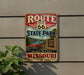 A vintage-style metal sign for Route 66 State Park in Missouri, featuring a red car and a scenic landscape.